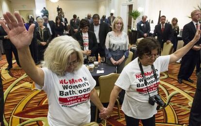 Rita Palomarez y Linda Rodriguez rezan durante una fiesta para seguir la votación en Houston.