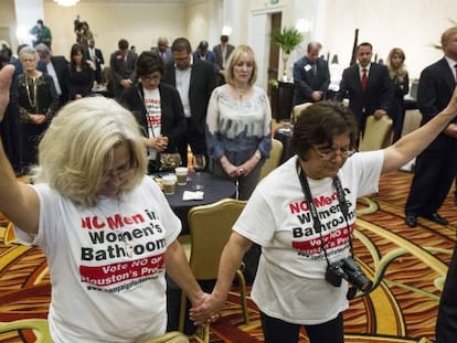 Rita Palomarez y Linda Rodriguez rezan durante una fiesta para seguir la votación en Houston.