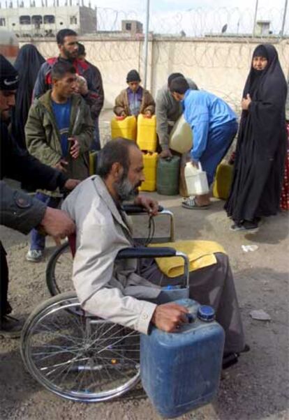 Varios iraquíes hacen cola para conseguir combustible en Bagdad.