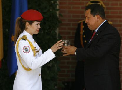 El presidente de Venezuela, Hugo Chávez, junto a una ayudante este viernes en su visita a Madrid.