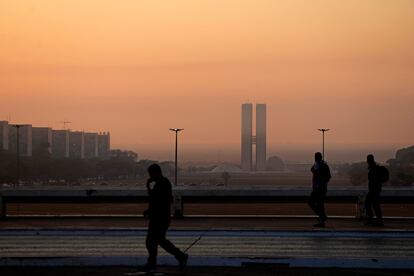 Transéuntes caminan entre el humo ocasionado por un incendio forestal en Brasilia, Brasil, el 16 de septiembre de 2024.