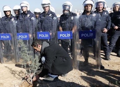 Las manifestaciones en el campus de ODTU en Ankara se han recrudecido después de que el ayuntamiento iniciara las obras durante la noche del 18 de octubre, el tercer y último día de la Celebración del Sacrificio, una festividad musulmana y reconocida oficialmente en Turquía, según denunció la propia universidad. En la foto, un hombre planta un árbol frente aa un grupo de antidisturbios.