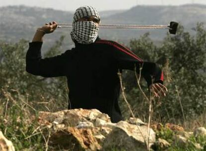 Un manifestante palestino utiliza una honda para lanzar piedras contra soldados israelíes en el pueblo de Bilin, cerca de Ramala.