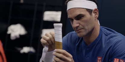 Federer wraps the handle of his racquet before taking to the court.