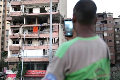 Un hombre hace una foto al bloque de viviendas atacado por un bombardeo israelí en Beirut, este lunes. 