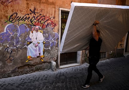 Un hombre pasa por delante de un graffiti con la imagen del Papa Francisco en una calle de Roma.