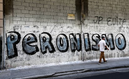 Un hombre pasa delante de un grafiti de propaganda que hace referencia al peronismo, en una calle de Buenos Aires