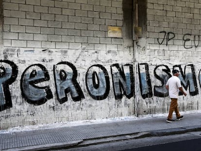 Un hombre pasa delante de un grafiti de propaganda que hace referencia al peronismo, en una calle de Buenos Aires