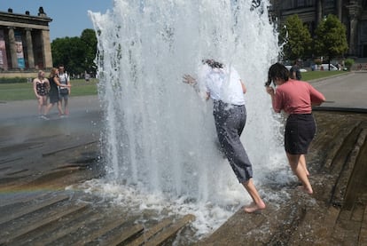 Dos mujeres se refrescan en una fuente del parque Lustgarten, este miércoles, en Berlín, Alemania.

