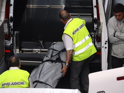 Dos funcionarios introducen los cuerpos de los menores fallecidos en un vehículo.