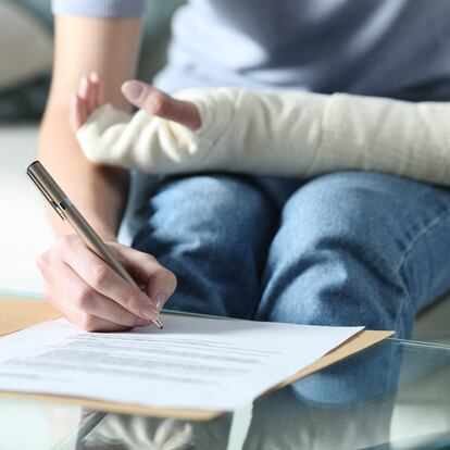 Disabled woman with bandaged arm signing document