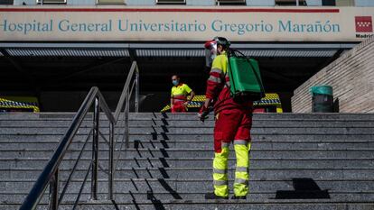 Un operario desinfecta el pasamanos de la escalera de la entrada principal del hospital Gregorio Marañón.