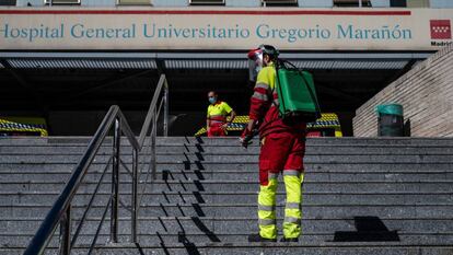Un operario desinfecta el pasamanos de la escalera de la entrada principal del hospital Gregorio Marañón.