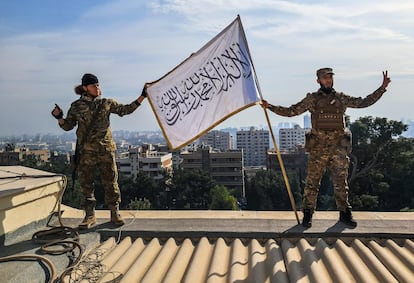 Dos combatientes fundamentalistas islmicos muestran una bandera con la profesin de fe mientras gritan 'Al es el ms grande' en el techo de la mansin de El Asad en Damasco.