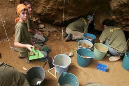 Los estudiantes que colaboran con Aranzadi, ayer, en la excavación del yacimiento arqueológico de Lezetxiki, en Mondragón.