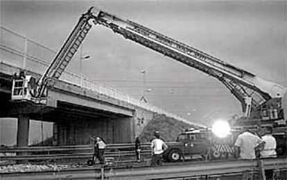 Bomberos y operarios de Obras Públicas trabajaban anoche para restablecer el tráfico bajo el puente de la N-340.