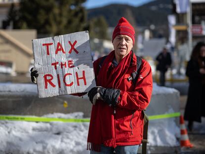 Un activista británico, con una pancarta en la que se lee "pongan impuestos a los ricos", el 18 de enero de 2023 en Davos (Suiza).