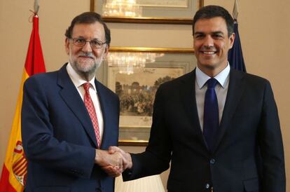 El presidente del Gobierno en funciones, Mariano Rajoy (i), y el secretario general del PSOE, Pedro Sánchez (d), se saludan al inicio de la reunión que están mantenido en el Congreso.