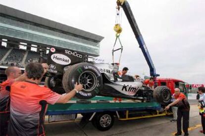 Una grúa retira de la pista el McLaren de Raikkonen