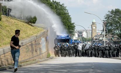 Manifestante corre do jato de água da polícia durante protesto contra o G20 em Hamburgo, na Alemanha.