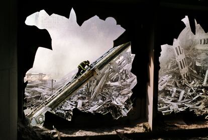 Un bombero es visto a través de las ventanas reventadas del World Trade Center.