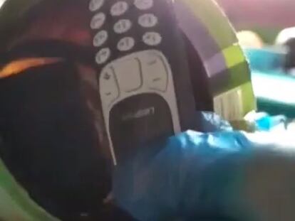 Imagen tomada del vídeo en el que se ve la intervención de un teléfono móvil dentro de la botella de producto limpiador que tenía un recluso en su celda.