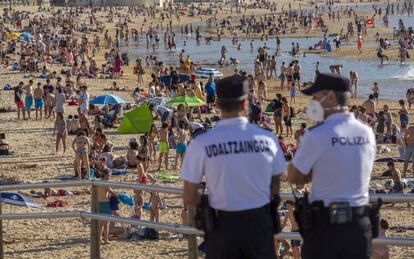 Dos agentes de policía de San Sebastián controlan el acceso a la playa de La Concha.