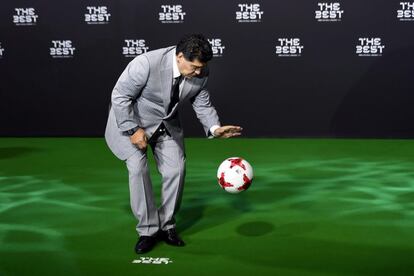 El exfutbolista argentino Diego Armando Maradona juega con un balón ante los fotógrafos a su llegada a la gala.