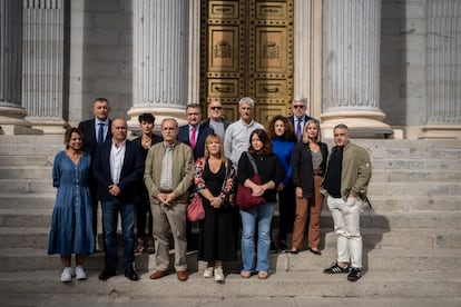 Representantes de la Asociación de Víctimas del Amiento de Euskadi (ASVIAMIE) posan en el exterior del Congreso con representantes parlamentarios.