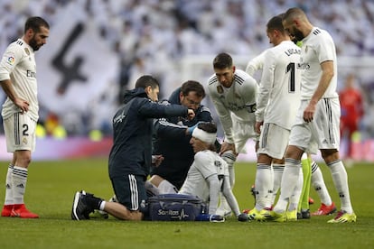 El jugador del Real Madrid Luka Modric (c) es atendido por el servicio médico tras recibir un golpe en la cabeza.