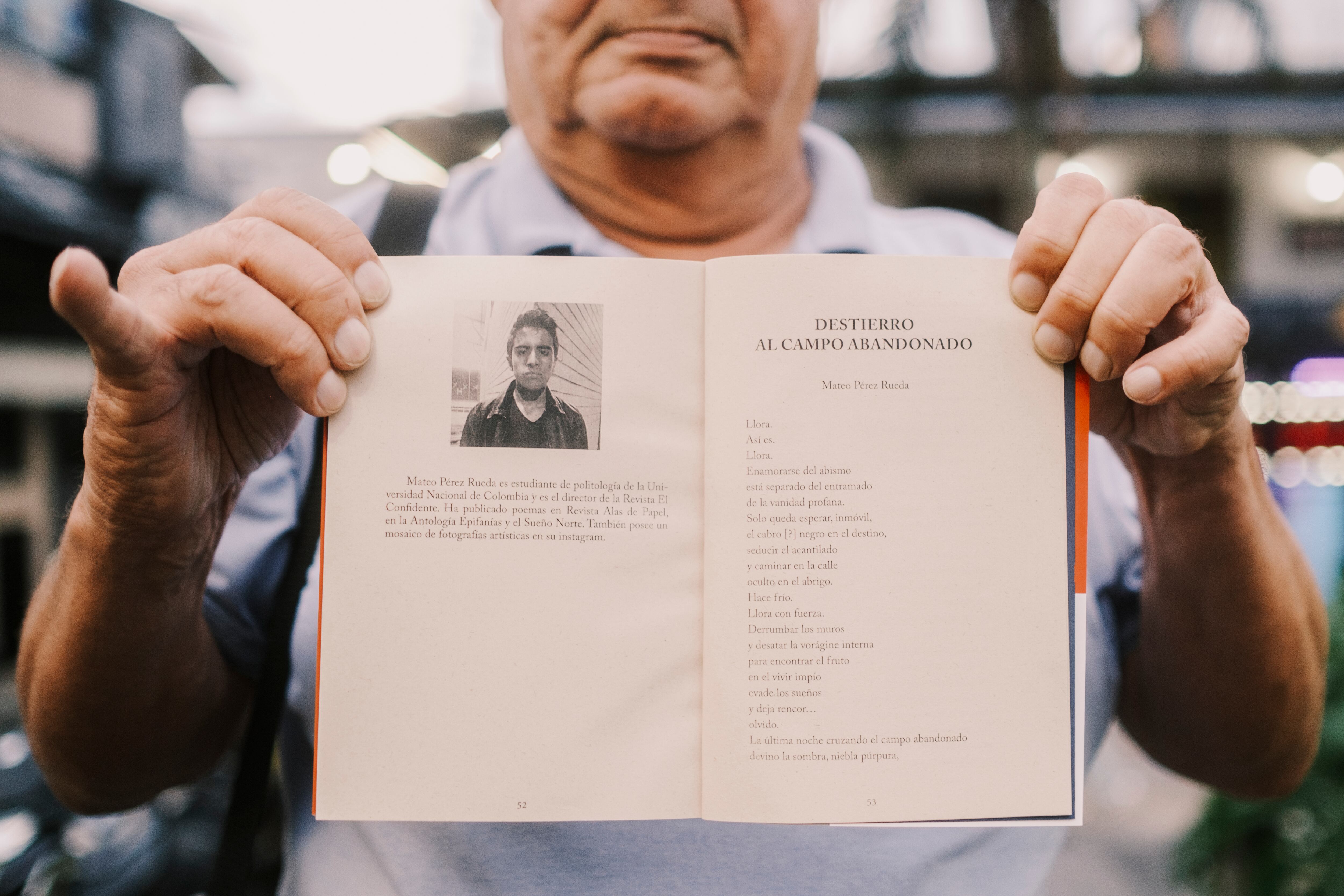 Hernán Echavarría, director del periódico El Yarumaleño, sostiene un libro con un poema escrito por Mateo Pérez.