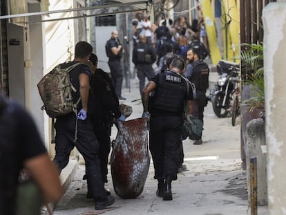 Policiais civis carregam o corpo de uma pessoa morta durante operação na favela do Jacarezinho, nesta quinta-feira, 6 de maio, no Rio de Janeiro.