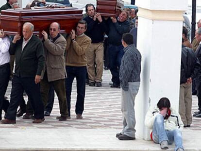 Familiares y amigos de los fallecidos trasladan sus ataúdes a la capilla ardiente.