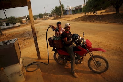 Margarida (L), owner of a petrol station, pumps petrol into bottles for an electric generator in Rio Pardo next to Bom Futuro National Forest, Rondonia State, Brazil, August 30, 2015. The town of Rio Pardo, a settlement of about 4,000 people in the Amazon rainforest, rises where only jungle stood less than a quarter of a century ago. Loggers first cleared the forest followed by ranchers and farmers, then small merchants and prospectors. Brazil's government has stated a goal of eliminating illegal deforestation, but enforcing the law in remote corners like Rio Pardo is far from easy. REUTERS/Nacho DocePICTURE 15 OF 40 FOR WIDER IMAGE STORY "EARTHPRINTS: RIO PARDO" SEARCH"EARTHPRINTS PARDO" FOR ALL IMAGES