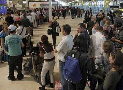 Largas colas de pasajeros esperan para informarse o poner reclamaciones en la T-4 del aeropuerto de Barajas.