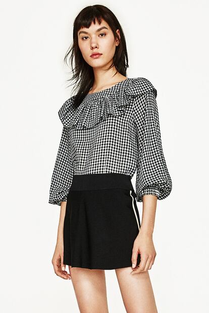 Los cuadros vichy vuelven un año más dispuestos a convertirse en el estampado de la primavera. Este top de Zara apuesta por el binomio blanco-negro (29,95 euros).