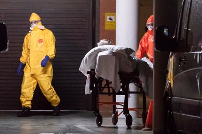 Enfermeiros do serviço de saúde de Múrcia, na Espanha, transferem um homem de uma casa de repouso para o hospital.