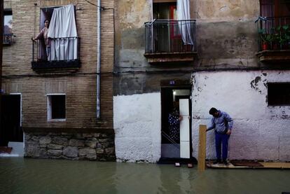 Vecinos de Tudela intentan evitar la entrada del agua en sus viviendas tras la subida del caudal del río Ebro, este domingo.