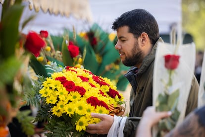 Un joven compra flores para regalar, tradición del día de Sant Jordi.