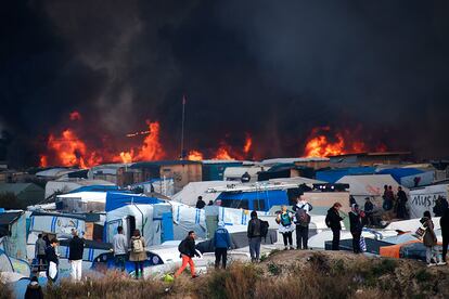 El fuego toma protagonismo en el campamento improvisado de Calais, durante el tercer día de evacuaciones, antes de ser derruido.