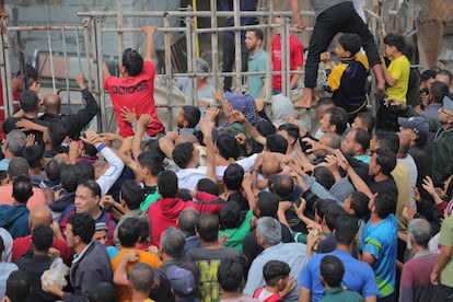 Una multitud de palestinos desplazados intentan acceder a una panadería donde se distribuye pan en el campo de refugiados gazatí de Nuseirat, este jueves.