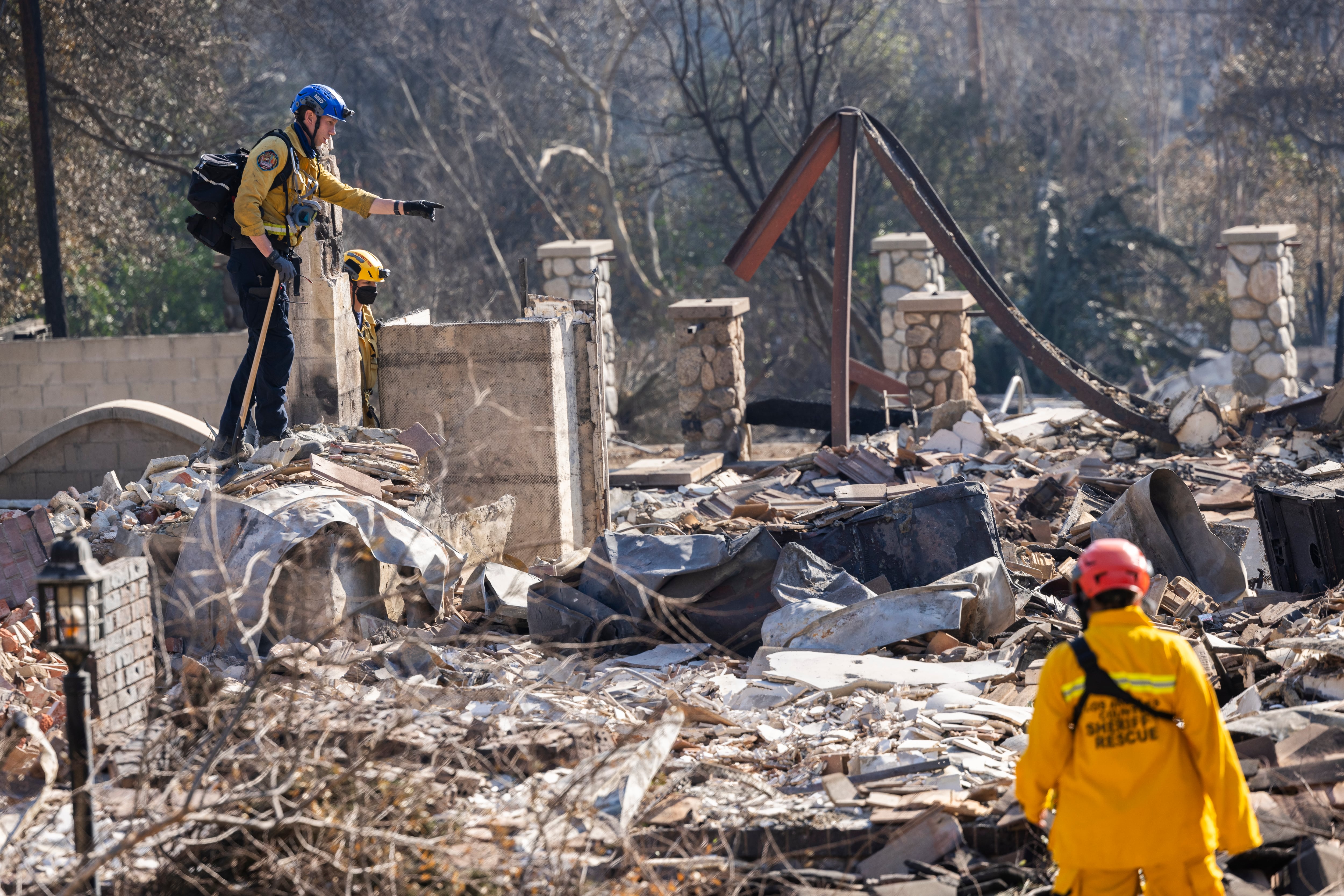 Equipos de rescate del condado de Los Ángeles inspeccionan una vivienda arrasada por el fuego en busca de cadáveres en Pasadena, California, el 11 de enero de 2025.