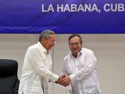 O líder das FARC, Rodrigo Londoño Echeverri, alias "Timochenko" (d), estreita a mão do presidente de Cuba, Raúl Castro.