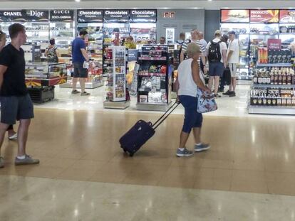 Viajeros ante una tienda de Dufry.