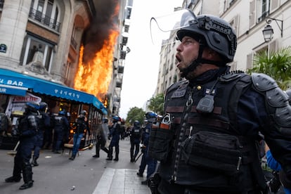 Un policía reacciona al proyectil que ha incendiado una cafetería en la plaza de Chatêlet, París.   