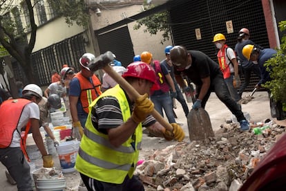 Trabajadores de los servicios de rescate continúan con sus labores de rescate entre los escombros de un edificio de Ciudad de México.