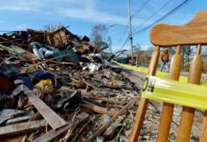 Un hombre camina junto a los escombros de una casa que fue destruida tras el paso del ciclón "Sandy" la semana pasada, en el barrio New Dorp Beach de Staten Island, Nueva York (EEUU).