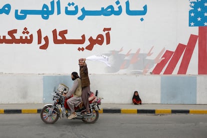 A Taliban supporter holds an Islamic Emirate of Afghanistan flag on the first anniversary of the fall of Kabul on a street in Kabul, Afghanistan, on August 15, 2022.