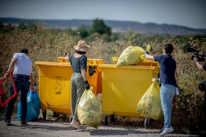 Varias personas depositan residuos en contenedores para el reciclaje de envases.