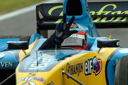 Fernando Alonso, triunfador en Imola, muestra con sus dedos sus tres victorias.